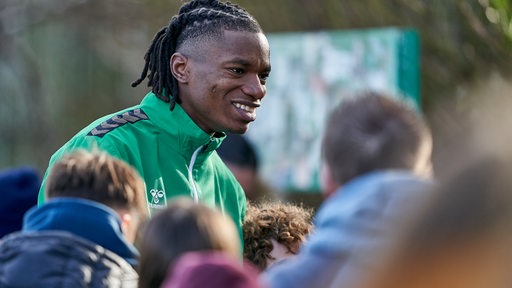 Werder-Neuzugang Skelly Alvero wird nach seinem ersten Training umringt von Fans, denen er lächelnd Autogramme gibt.