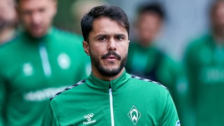 Werder-Profi Leonardo Bittencourt schaut nachdenklich auf dem Weg zum Trainingsplatz.