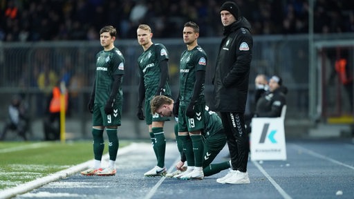 Werder-Trainer Ole Werner am Spielfeldrand des Testspiel bei Eintracht Braunschweig mit den Einwechselspielern um Rafael Borré neben sich.