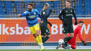 Eintracht Braunschweigs Spieler Fabio Kaufmann bejubelt seinen Treffer, die Werder-Spieler Jens Stage und Marco Friedl schauen frustriert.