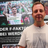 Der Host Dino Bernabeo steht im Vordergrund. Dahinter sieht man das Bild des jubelnden Werder-Spielers Marco Friedel.