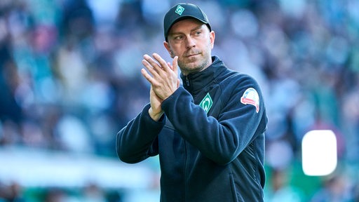 Werder-Trainer Ole Werner applaudiert nach dem Spiel gegen St. Pauli den mitgereisten Fans im Stadion.