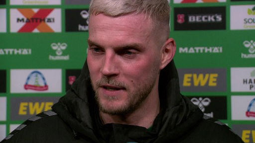 Werder-Stürmer Marvin Ducksch steht nach dem Spiel in Stuttgart vor einer Werbewand beim Interview.