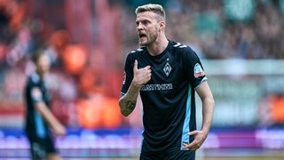 Werders Marvin Ducksch zeigt mit dem Finger auf sich selbt und reißt den Mund auf.