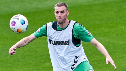 Werder-Stürmer Marvin Ducksch fixiert während des Trainings den heranfliegenden Ball.