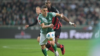 Werder-Stürmer Rafael Borré im engagierten Laufduell mit einen Frankfurter Gegenspieler.