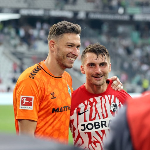 Werder-Torwart Jiri Pavlenka und Ex-Werder-Spieler Maximilian Philipp liegen sich nach dem Spiel lächelnd in den Armen. Philipp hatte das entscheidende Tor erzielt.