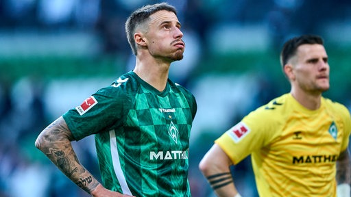 Werder-Kapitän Marco Friedl bläst nach dem Spiel gegen Sankt Pauli frustriert die Backen auf und stützt die Hände in die Hüften.
