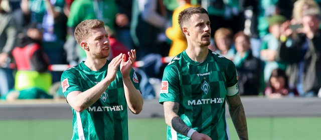 Werders Fußballer Mitchell Weiser und Marco Friedl gehen nach Spielende gegen Bochum über den Platz.
