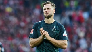 Werder-Stürmer Niclas Füllkrug applaudiert nach der Niederlage in Freiburg nachdenklich den Bremer Fans.