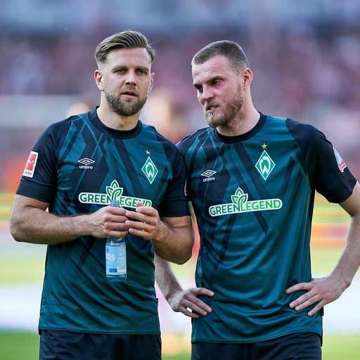 Die Werder-Stürmer Niclas Füllkrug und Marvin Ducksch stehen nach dem Saisonfinale auf dem Spielfeld im Gespräch zusammen.