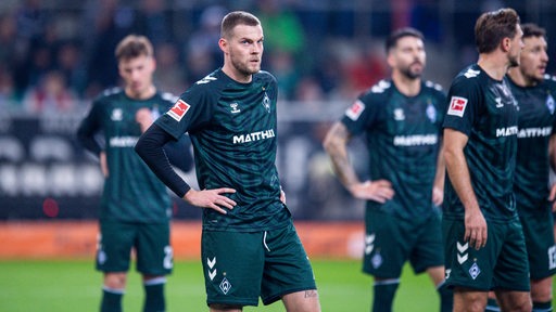 Werder-Spieler um Marvin Ducksch stehen frustriert nach der Niederlage in Mönchengladbach auf dem Rasen.