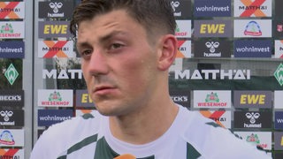 Werder-Stürmer Dawid Kownacki nach dem Testspiel gegen Toulouse im TV-Interview vor einer Werbewand.