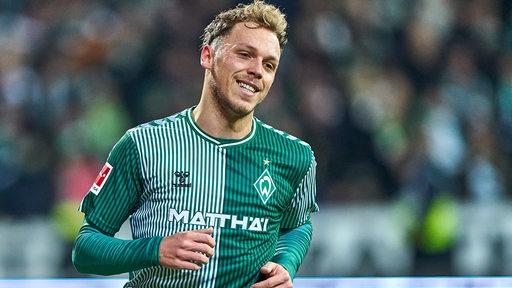 Werder-Spieler Senne Lynen lächelt am Rande eines Spiels.