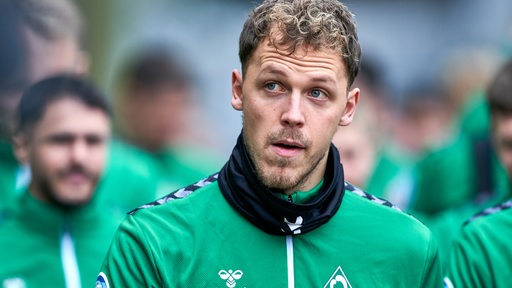 Werder-Profi Senne Lynen schaut kurz auf während er mit der Mannschaft zum Trainingsplatz geht.