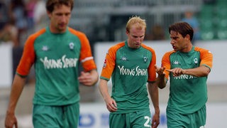 Die Werder-Spieler Marco Reich und Ludovic Magnin diskutieren auf dem Weg aus der Kabine über die Fehler im Spiel gegen Pasching, neben ihnen Frank Baumann.