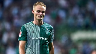 Werder-Spieler Amos Pieper geht mit ernster Miene und hängendem Kopf vom Spielfeld.