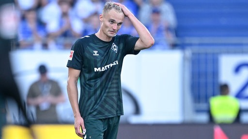 Werder-Verteidiger Amos Pieper fährt sich auf dem Spielfeld enttäuscht durch die Haare.