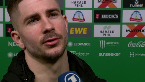 Werder-Profi Romano Schmid steht nach der Niederlage gegen Gladbach vor einer Werbewand bei einem Interview.