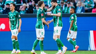 Werder-Spieler Mitchell Weiser tätschelt seinem Mitspieler Oliver Burke tröstend den Kopf nach seinem nicht gegebenen Tor gegen St. Pauli.