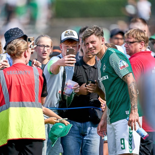 Werder-Neuzugang Dawid Kownacki gibt nach dem Testspiel vielen wartenden Fans Autogramme und macht Selfies.