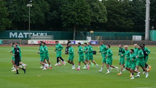 Werder-Spieler laufen sich als Gruppe warm beim ersten Training nach der Sommerpause.