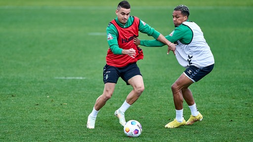 Die Werder-Profi Felix Agu und Rafael Borré während des Trainings im Zweikampf.