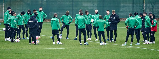 Werder-Spieler stehen während des Trainings im Kreis um Trainer Ole Werner herum und hören zu.