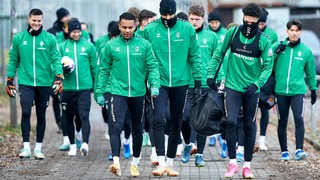 Werder-Spieler gemeinsam auf dem Weg zum Trainingsplatz.