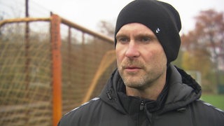 Werders Torwart-Trainer Christian Vander steht am Rande des Trainingsplatzes bei einem Interview.