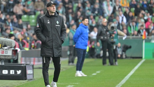 Werder-Trainer Ole Werner steht am Spielfeldrand im Weser-Stadion während des Spiels gegen Darmstadt und schaut nachdenklich nach oben.