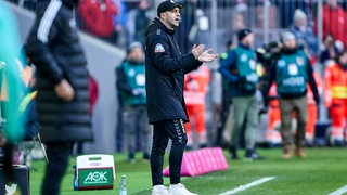 Werder-Trainer Ole Werner klatscht motivierend an der Seitenlinie im Spiel gegen Bayern München.