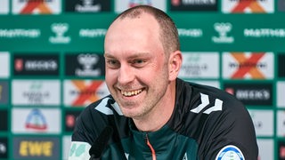 Ole Werner lacht bei einer Pressekonferenz