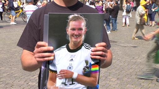 Ein Bild der Capitainin der deutschen Fußball Frauen Nationalmanschaft Popp wird von einer Person gehalten.
