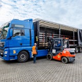 Ein Gabelstaplerfahrer belädt einen Lastwagen.