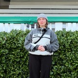 Eine Frau steht vor einer weißen Tribüne aus Holz.