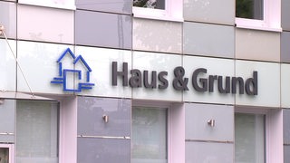 Das Logo von dem Verein "Haus & Grund" an einer Hauswand.