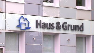 Das Logo von dem Verein "Haus & Grund" an einer Hauswand.