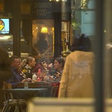 Mehrere Personen sitzen an Tischen eines Restaurants.