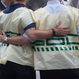 Zwei Männer mit GDL-Westen halten sich gegenseitig im Arm.