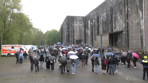 Die Teilnehmenden des Gedenkmarsches vor dem Bunker bei Regenwetter.