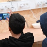 Zwei Jugendliche blicken auf ein Smartphone.