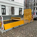 Eine gelbe Bank mit angeschlossenen Blumenkästen und einer Gitterwand vor dem Sichtfeld steht in Bremerhaven.