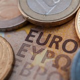 Mehrere Euro-Münzen liegen auf einem Euro-Schein.