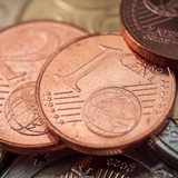 Cent- und Euro-Münzen liegen übereinander.