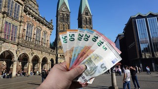 Ein Fächer aus verschiedenen Geldscheinen am Marktplatz vor dem Bremer Rathaus.