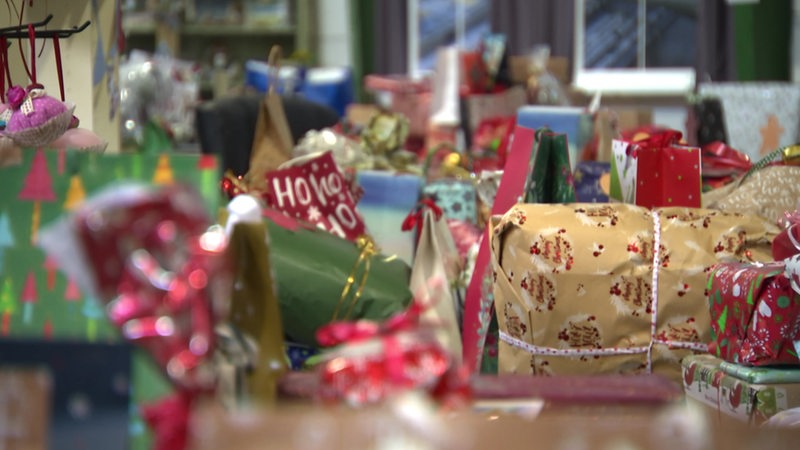 Viele Geschenke, im Hintergrund scharf gestellt, im Vordergrund unscharf. Alle weihnachtlich verpackt.
