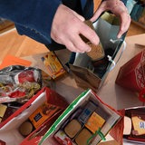 Ein Mann packt Spenden in eine Geschenktüte zu Weihnachten.