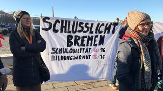 Menschen demonstrieren vor der Bremer Stadthalle