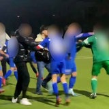 Menschen in unterschiedlichen Trikots gehen aufeinander los und prügeln sich